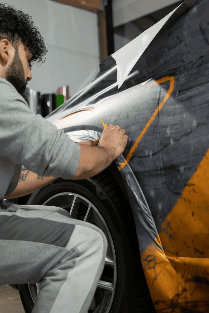 Mitarbeiter von Autofolierung Frankfurt beim Anbringen einer farbigen Lackschutzfolierung auf einem Fahrzeug – professionelle Autofolierung in Frankfurt.
