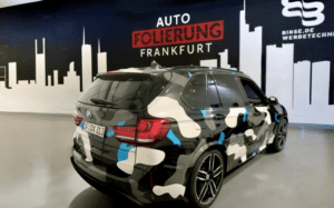 BMW SUV mit individueller Camouflage-Designfolierung im Showroom von Auto Folierung Frankfurt
